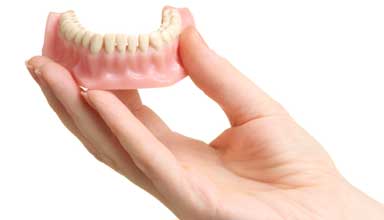 Patient holding custom-made, full dentures