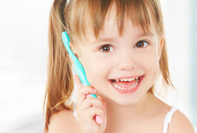 young child holding a toothbrush
