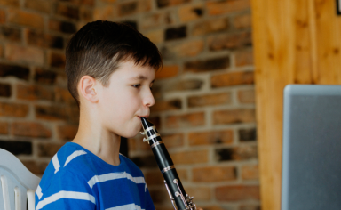 Child playing instrument in virtual classroom