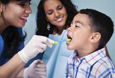  Pediatric dentist performing a checkup on a young dental patient